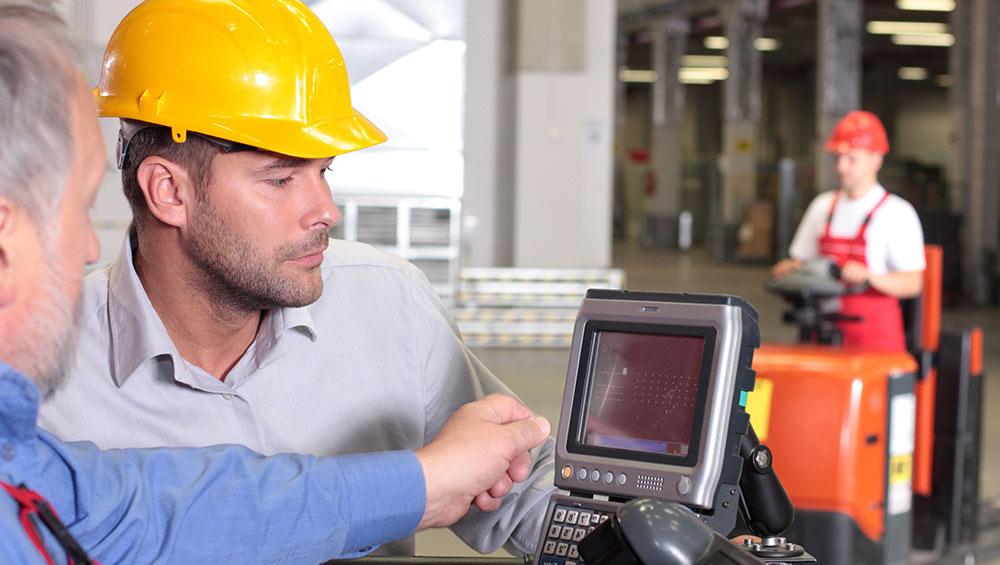 Construction workers looking at technology on a job site.