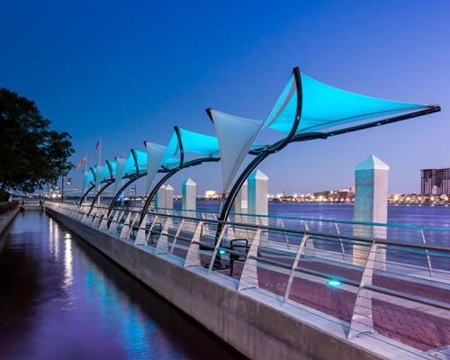 Photo of Jacksonville's Southbank Riverwalk at dusk. Blue LED lights illuminate the canopies.